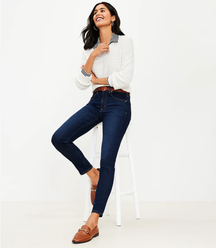 Business casual outfit idea with jeans, a sweater layered over a button-down shirt, and simple loafers