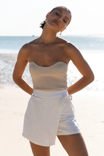 Minimal swimsuit outfit: Strapless one-piece bathing suit paired with a simple white skort