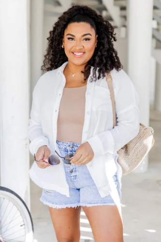 One piece bathing suit paired with linen button-down shirt and denim shorts