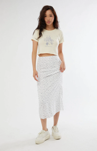 Soft girl outfit with cropped graphic tee and pastel floral midi skirt plus sneakers