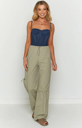 Comfortable outfit with corset top: Light green khaki parachute cargo pants, navy blue corset top, brown foam slide sandals