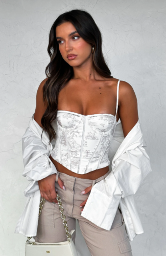Night out corset outfit with white printed corset, gray cargo pants, white mens button-down shirt, white chain strap bag, hoop earrings