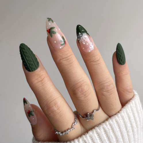 Christmas nail art design with green sweater nails, white snowflake detailing, and mistletoe